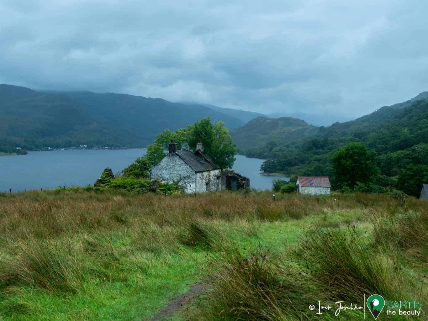 old little houses next to a lake (loch lomond)